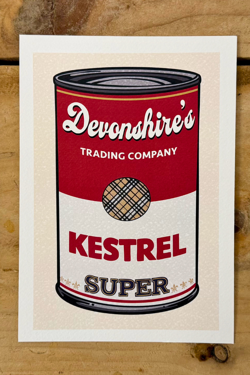 A pop-art style illustration of a soup can, mimicking the classic Campbell's design. The top half is red with "Devonshire's Trading Company" in white script. The bottom half is white with the word "KESTREL" in large red block letters and "SUPER" in gold-outlined letters below it. In the centre is a circular logo featuring a tan and black plaid pattern.